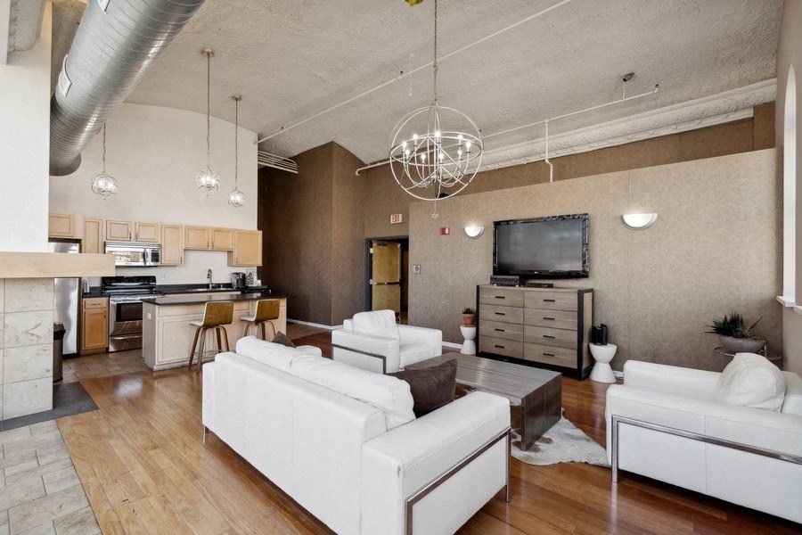 a large living room with white chairs and a table