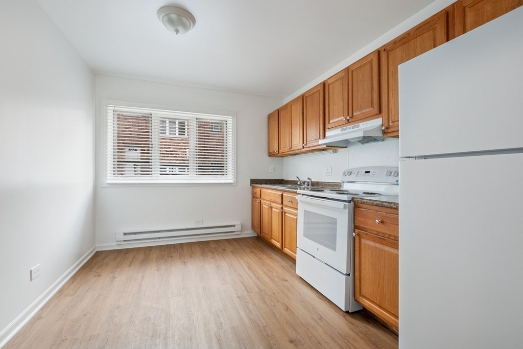 A kitchen with wooden cabinets and white appliances.
