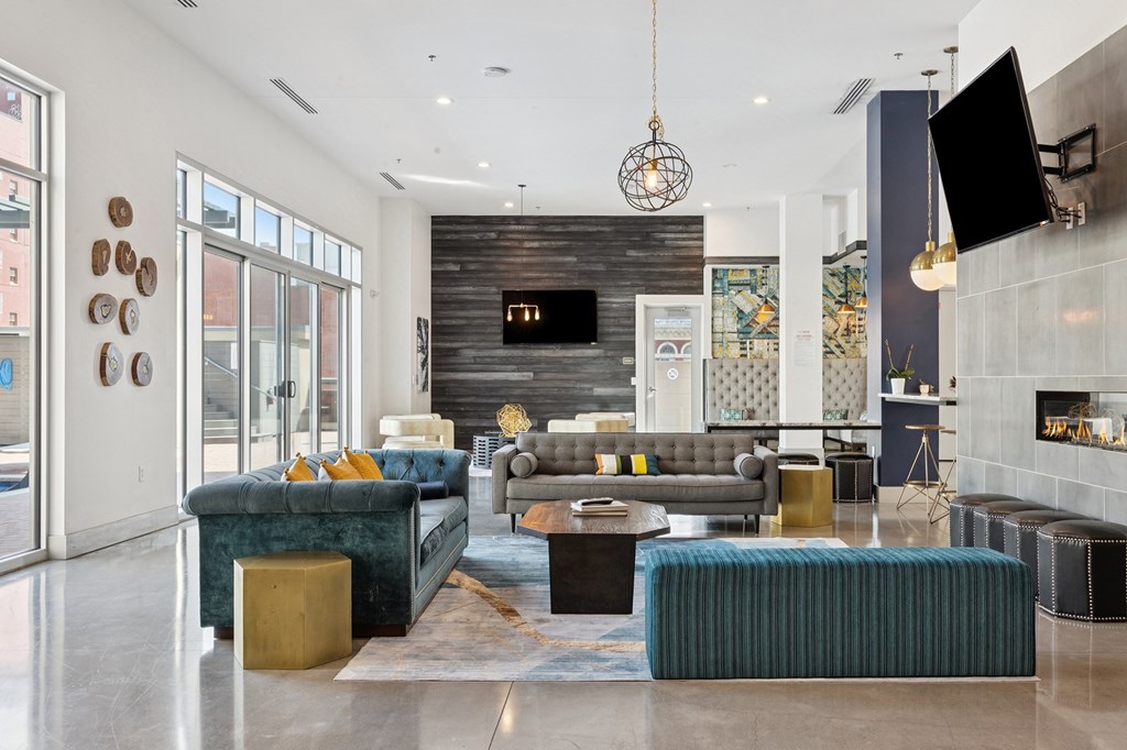 A modern living room with a dark wood accent wall and a large flat screen TV mounted above the fireplace.