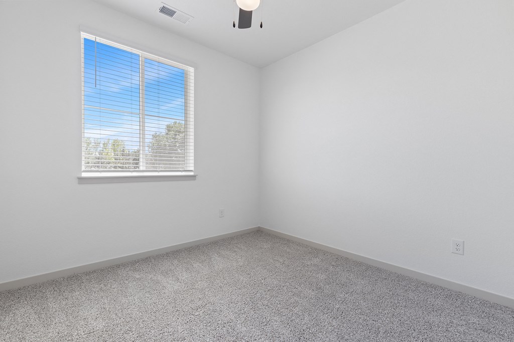 an empty room with white walls and a window