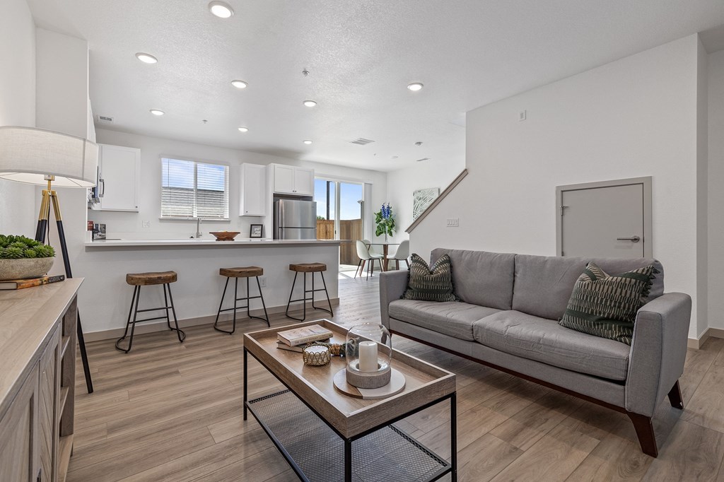 a living room with a couch and a kitchen with a bar