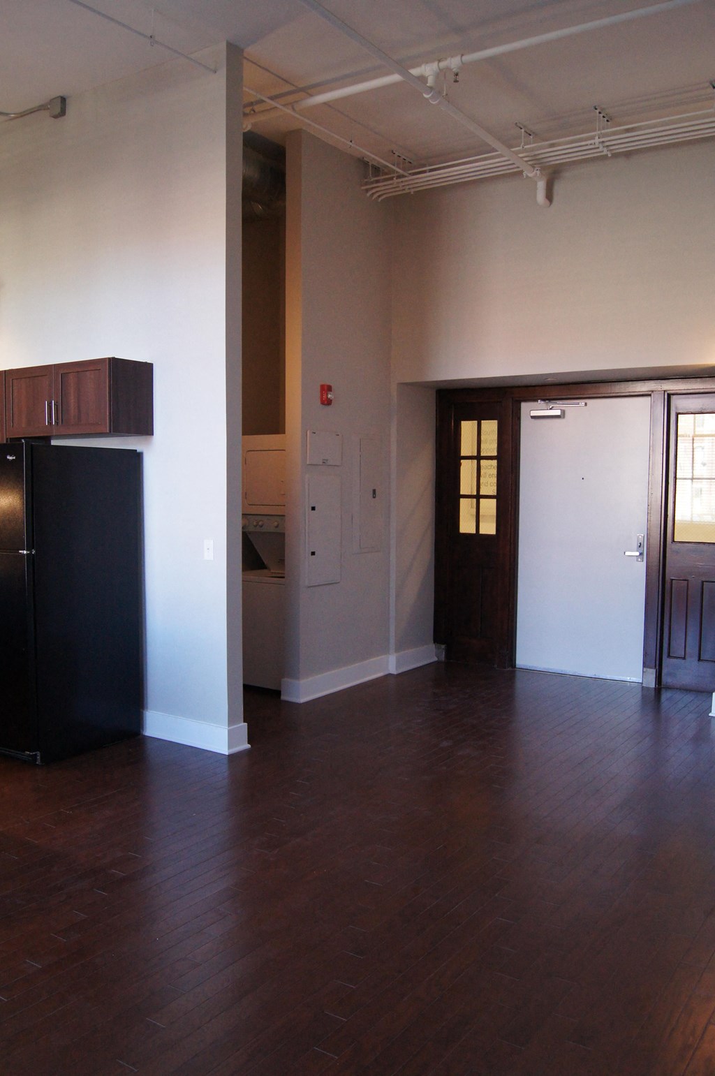empty living room with a refrigerator and a door