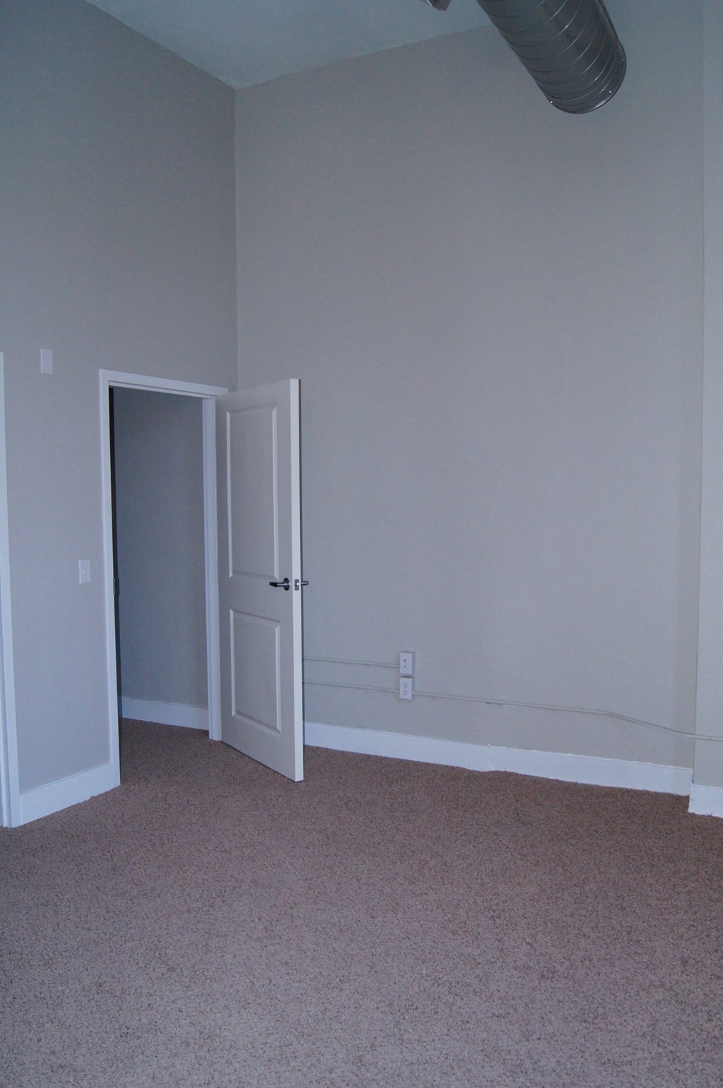 an empty room with a door open to a closet