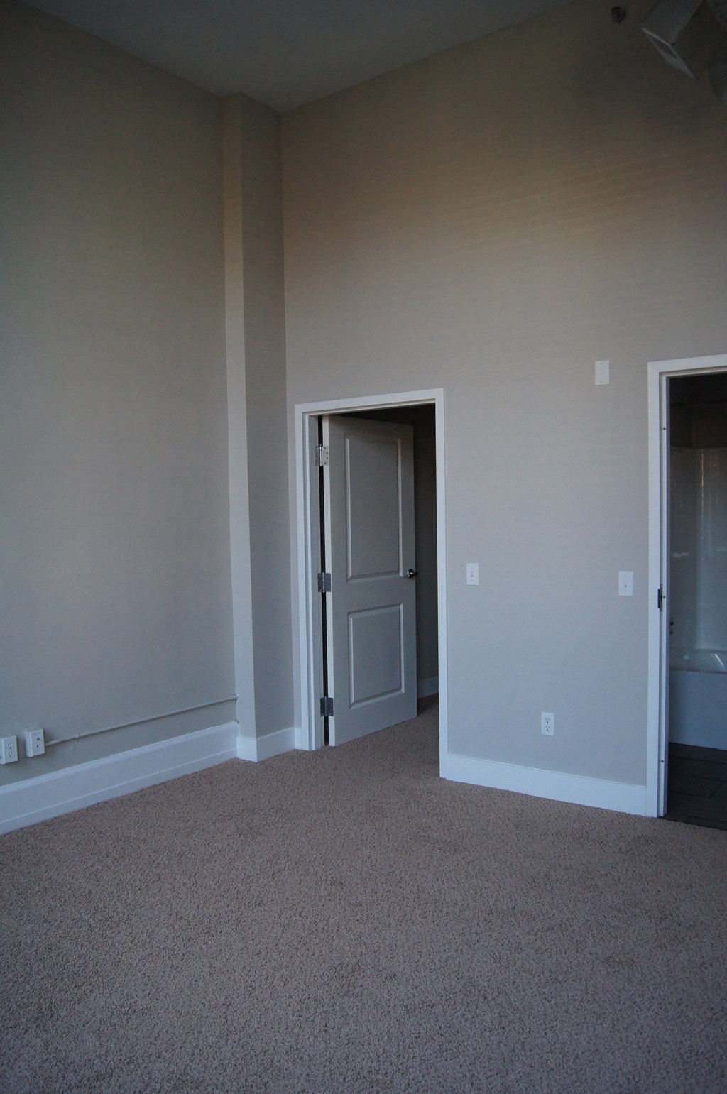 Bedroom with a door and a carpeted floor