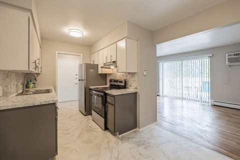 an open kitchen with stainless steel appliances and marble counter tops