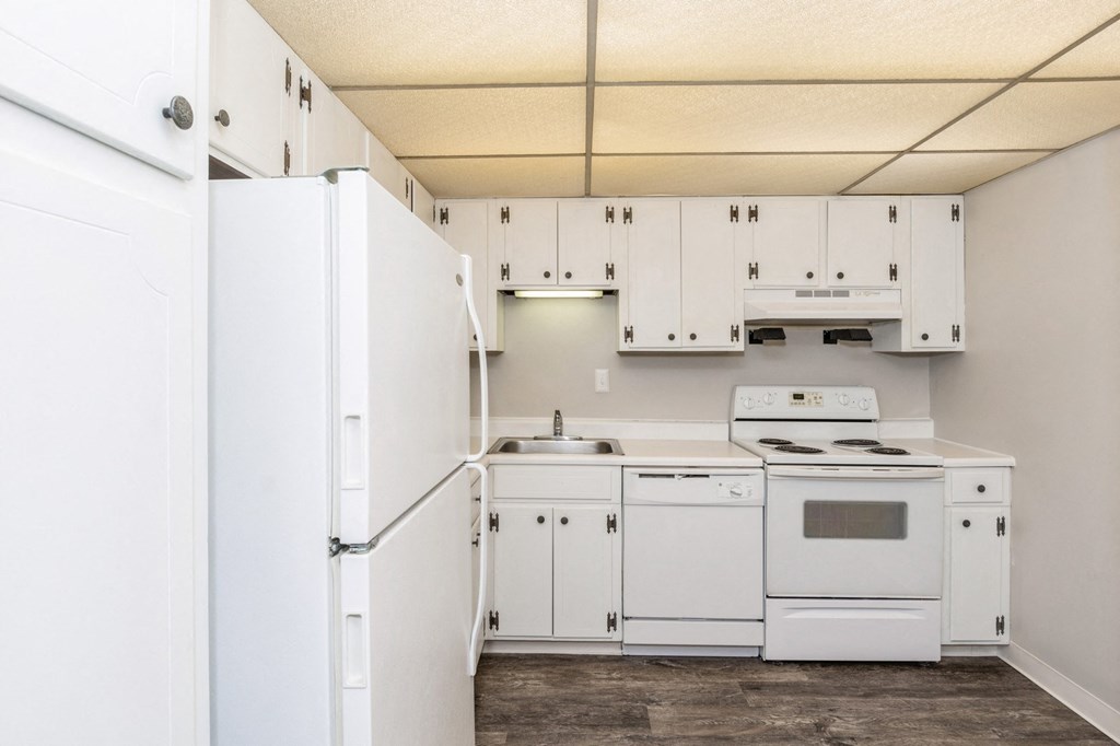 A spacious kitchen with white kitchen appliances and white cabinets