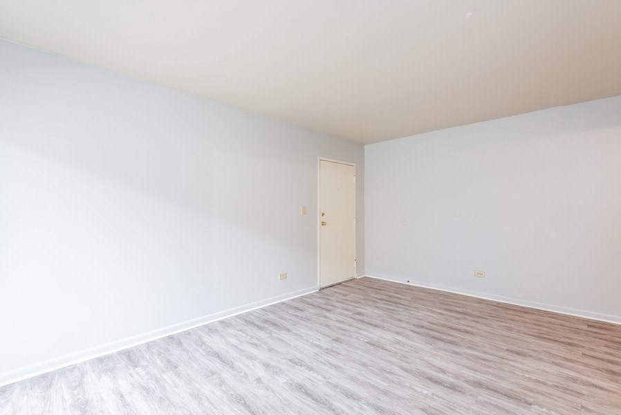 A room with a wooden floor and a white door.