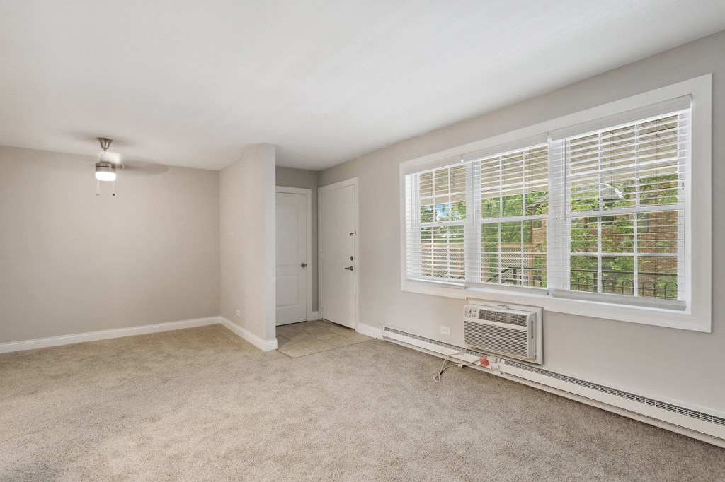 a bedroom with a large window and an air conditioner at The Hinsdale, Illinois, 60521