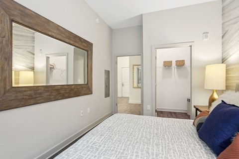 a bedroom with a bed and a mirror on the wall