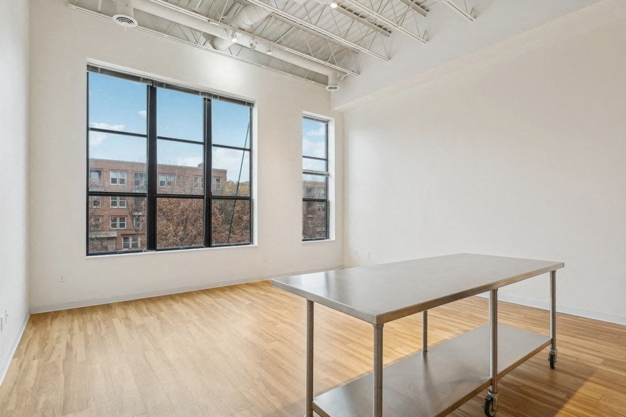 A room with a table and a window overlooking a building.