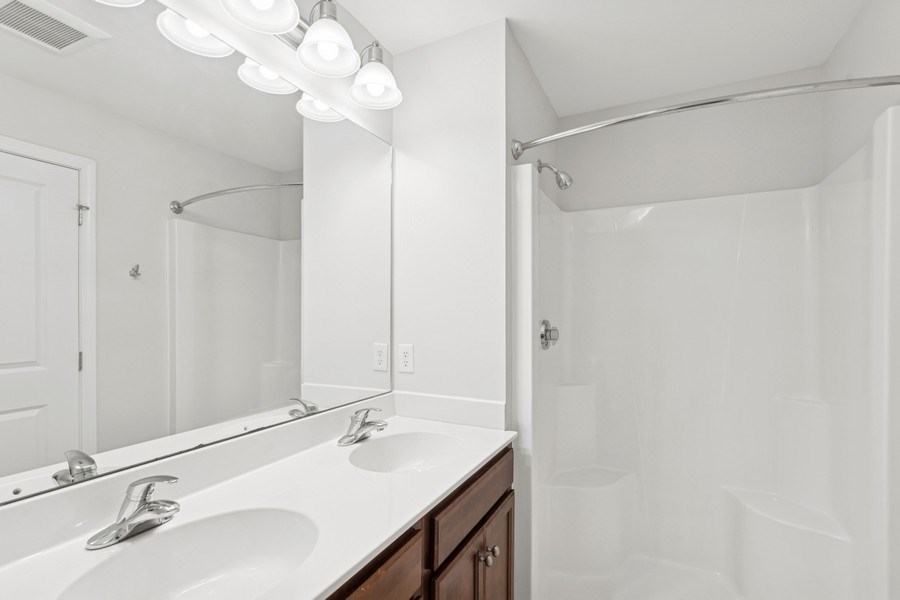 A white bathroom with a sink and mirror.