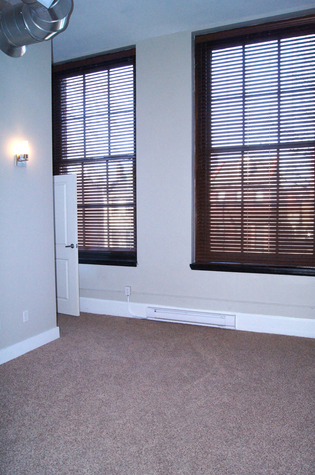 empty living room with two windows and a door