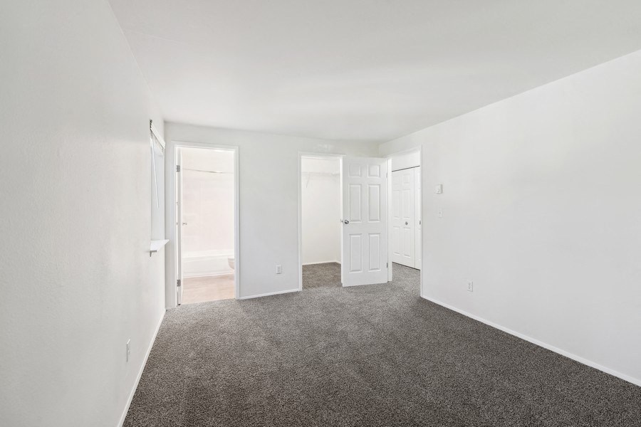 an empty room with carpet and white walls