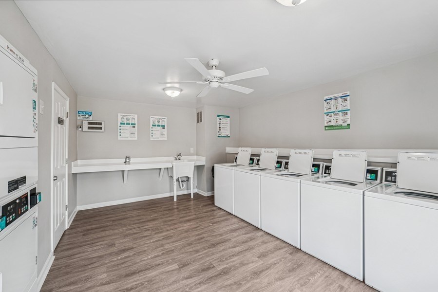 A laundry room with a row of washers and dryers.