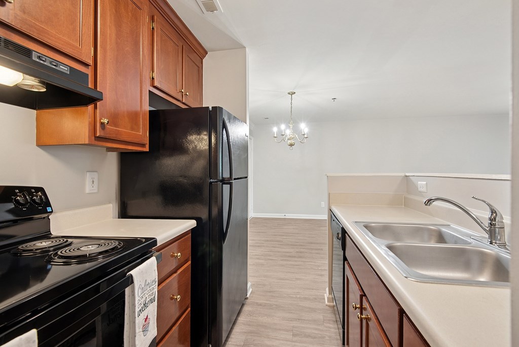 A kitchen with black appliances and wooden cabinets.