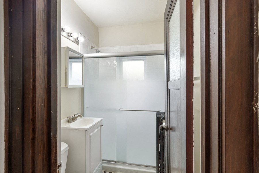 a white bathroom with a shower and a sink