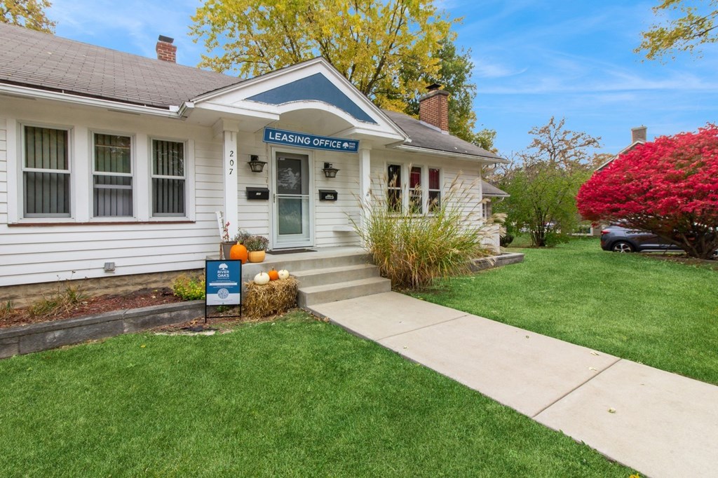 a white house with a lawn and a sidewalk in front of it at River Oaks, North Aurora