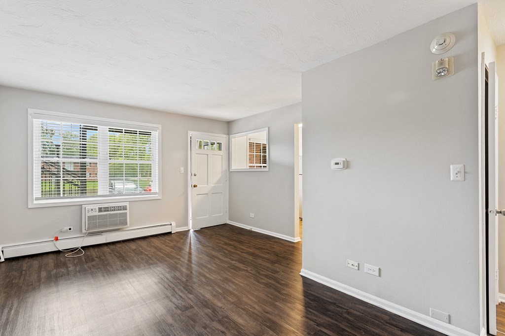 a bedroom with hardwood floors and grey walls at The Hinsdale, Illinois