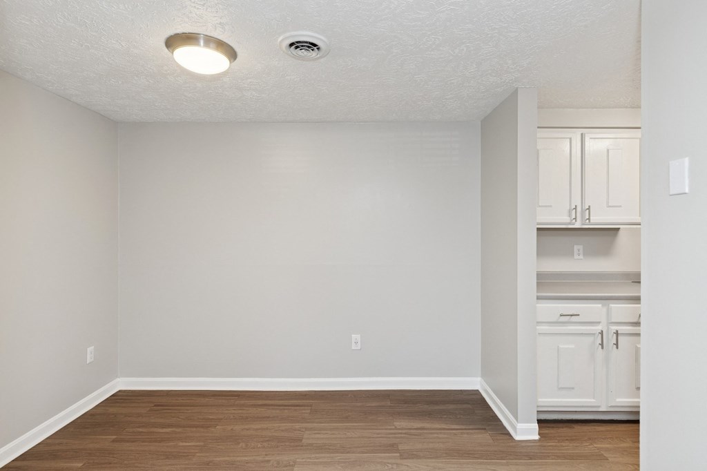 A room with a white ceiling and wooden floor.