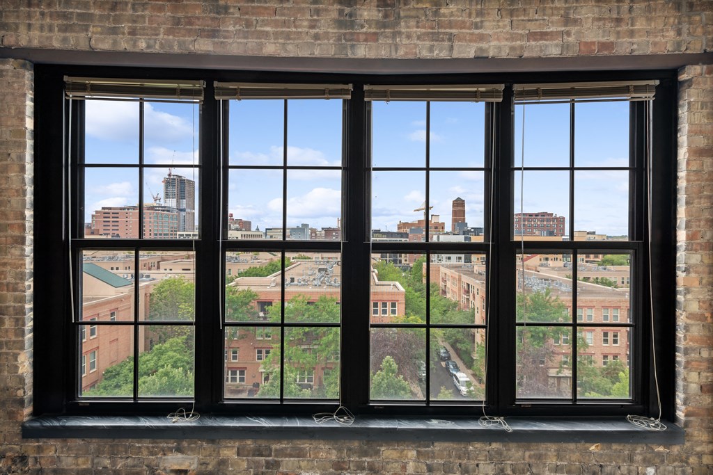 a large window in a brick wall with a view of the city at Gaar Scott Historic Lofts, Minnesota, 55401