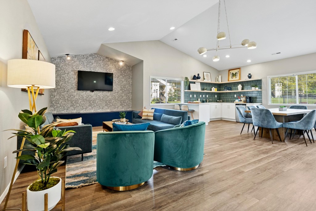 A living room with a green sofa and a television on the wall.