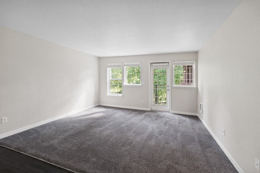 an empty room with white walls and a carpet at Sundial Apartments, Wilsonvile, Oregon