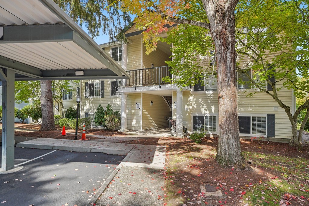 a covered parking space in front of an apartment building