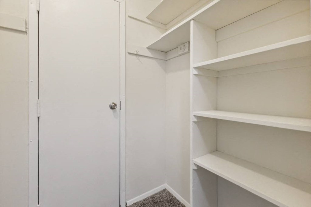 a closet with white shelves and a door at Briarwood Apartments, Dumfries, Virginia