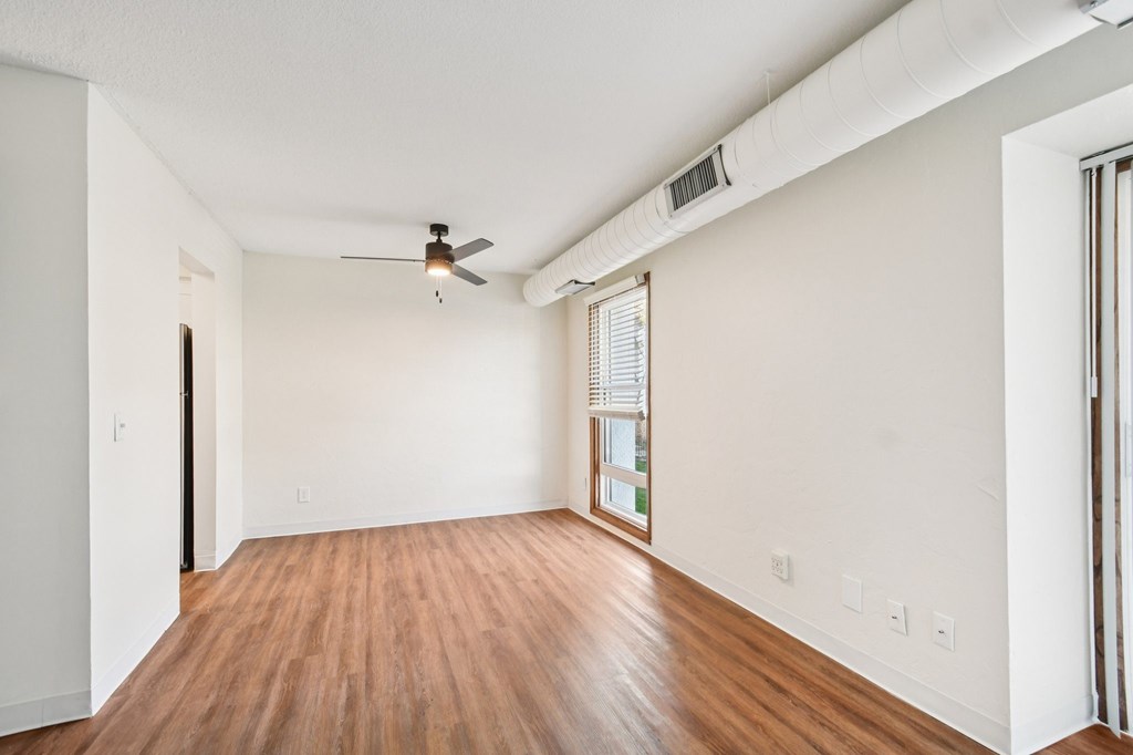 A room with wooden floors and a ceiling fan.