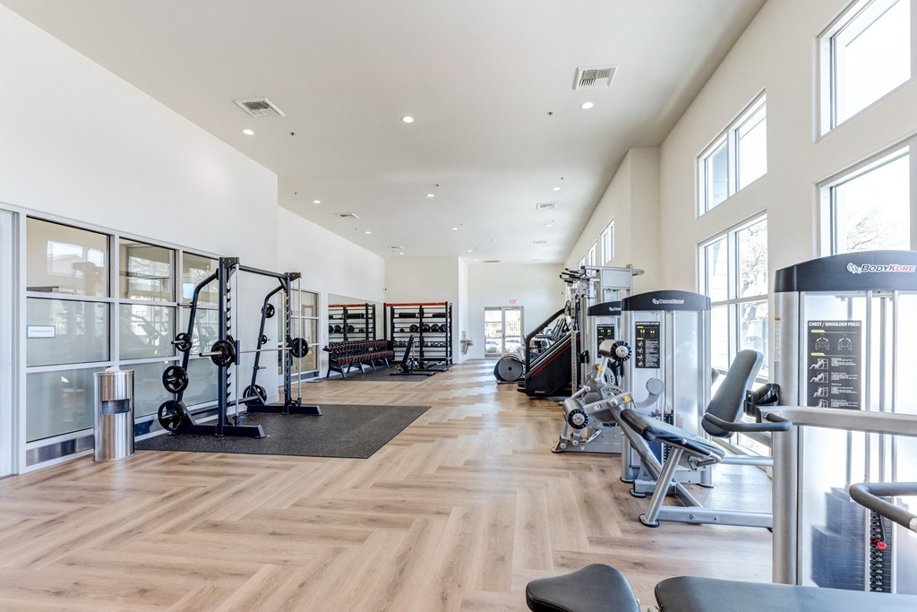 A gym with a variety of equipment including weights and cardio machines.