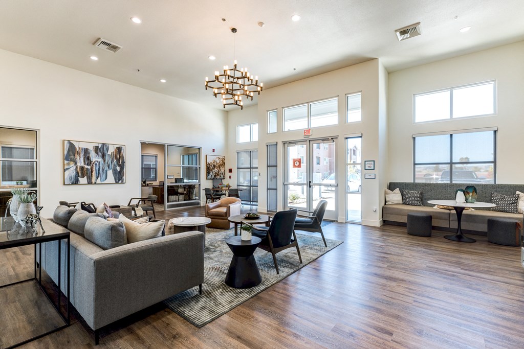 A spacious living room with a grey sofa and a wooden floor.