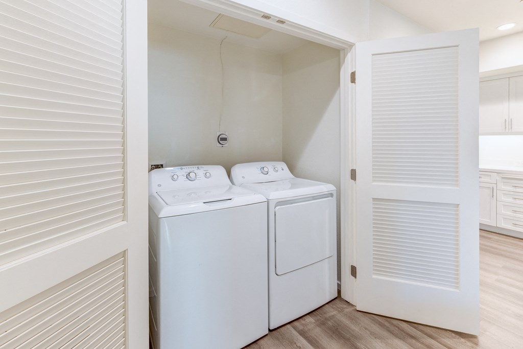 A white washing machine and dryer in a small laundry room.