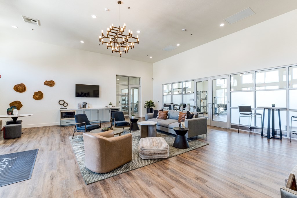 A modern living room with a wooden floor and a large chandelier.