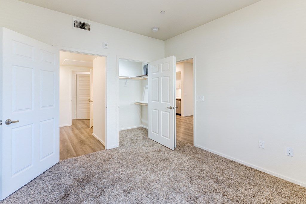 A room with white walls and a grey carpet.