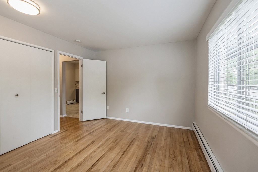 an empty living room with wood flooring and a large window