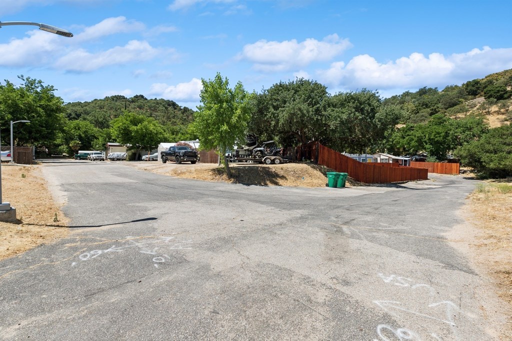 A road with white graffiti on it and a hill in the background.