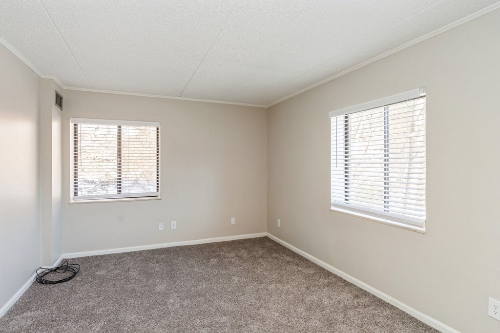 A room with a window and a hose on the floor.