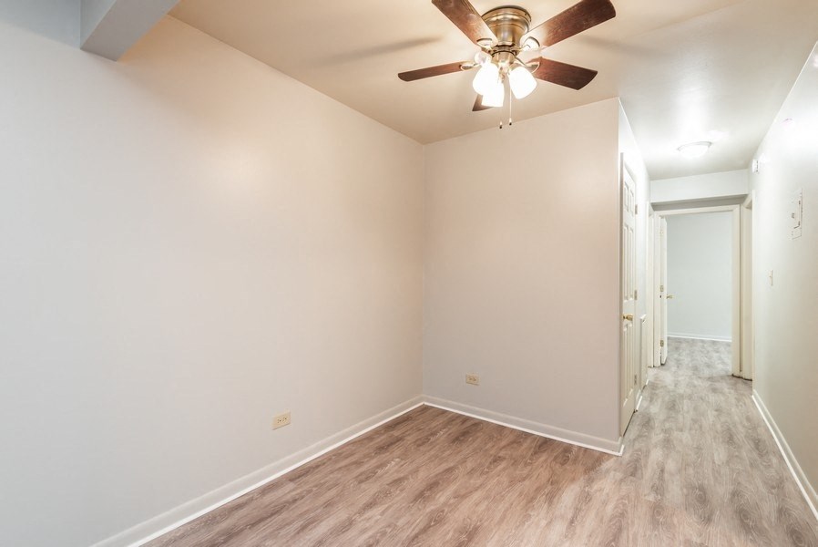 A room with a ceiling fan and light fixture.