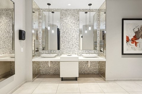 a bathroom with two sinks and three mirrors