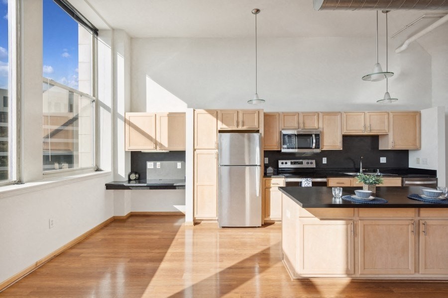 a large kitchen with wood floors and a large window