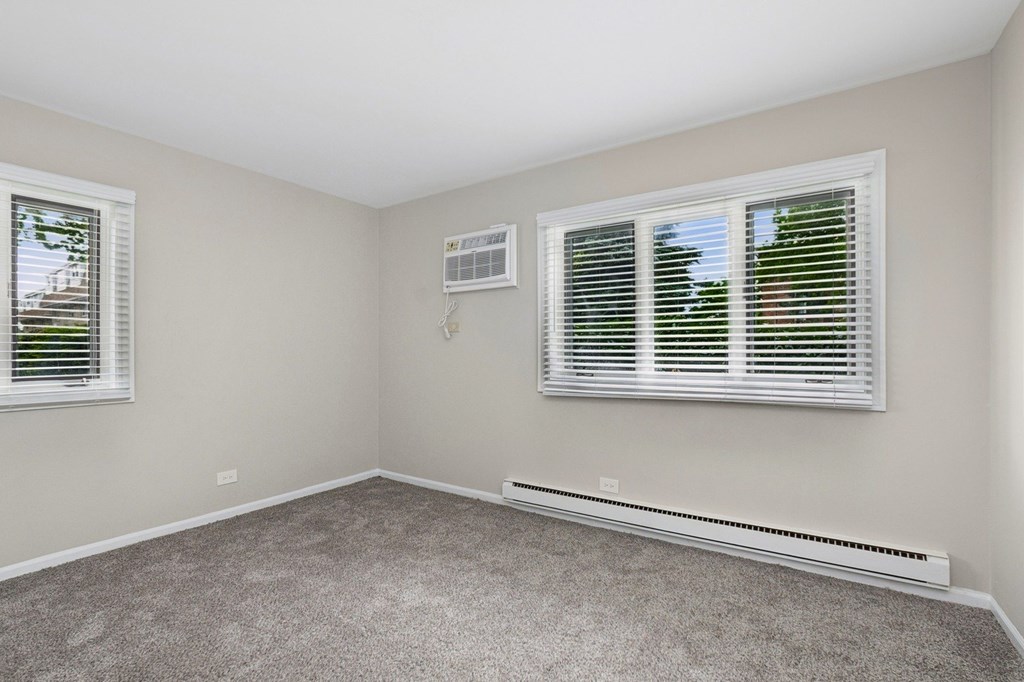 A room with a window and a wall-mounted air conditioner.