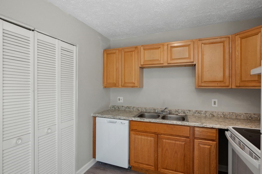 a kitchen with wooden cabinets and a white dishwasherat Fort Collier Terrace, Winchester, 22601