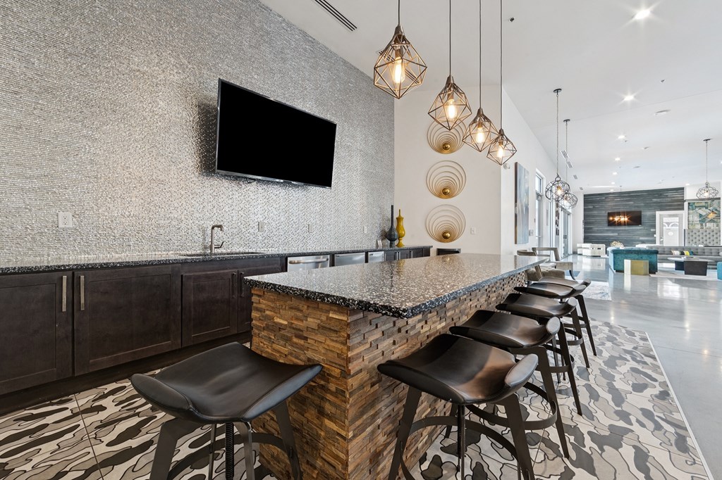 A modern table with a stone counter and black stools.