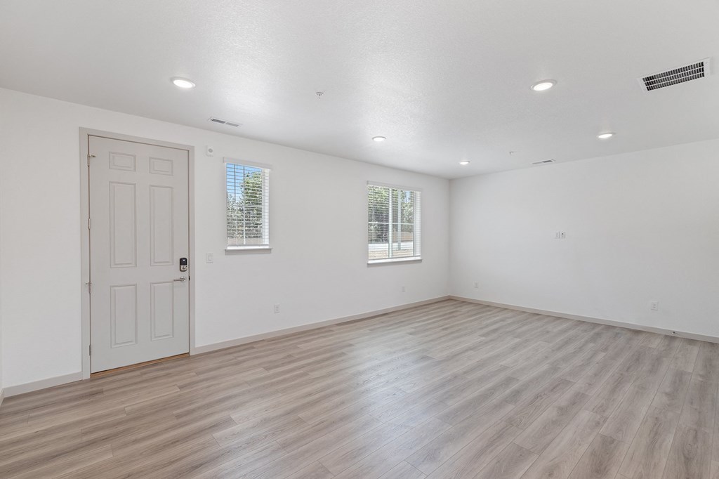 the living room of an empty house with white walls and a door