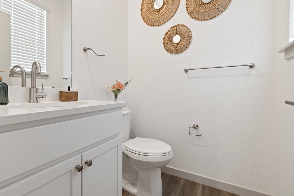 a white bathroom with a toilet and a sink