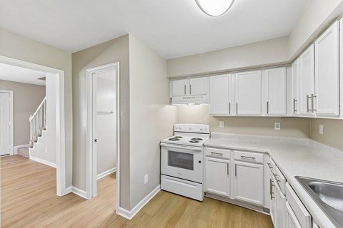 A kitchen with white cabinets and appliances.