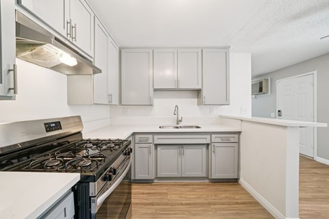 A kitchen with a stove top oven and a sink.