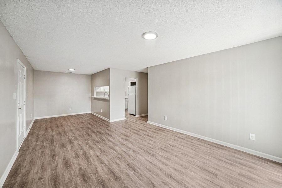 A room with light brown flooring and white walls.