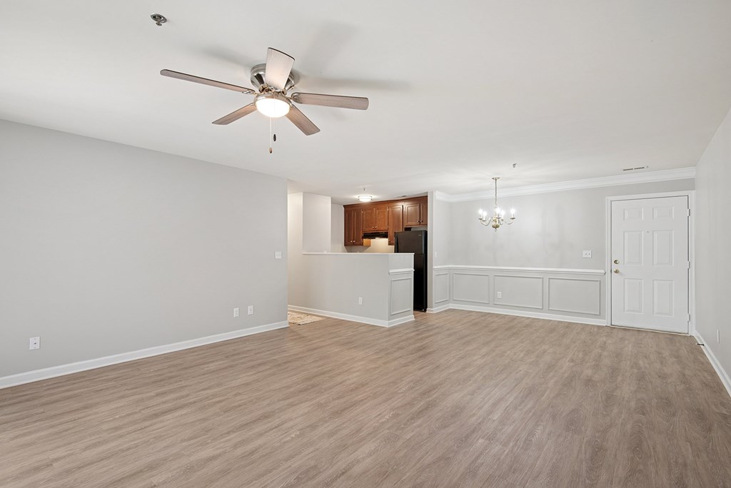 A room with a ceiling fan and wooden flooring.