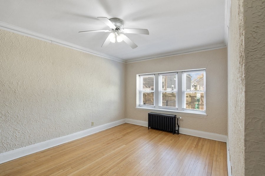 an empty living room with a ceiling fan and a window